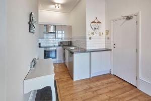 a kitchen with white appliances and a white counter top at Apartment 2, Khyber Lodge Apartment Whitby in Whitby