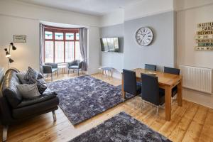 uma sala de estar com mesa e cadeiras e um relógio em Apartment 3, Khyber Lodge Apartments Whitby em Whitby