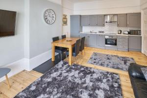 a living room with a table and a kitchen at Apartment 3, Khyber Lodge Apartments Whitby in Whitby +6 photos