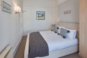 een slaapkamer met een groot wit bed met kussens bij Apartment 3, Khyber Lodge Apartments Whitby in Whitby