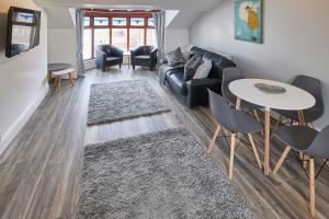 ein Wohnzimmer mit einem Sofa, einem Tisch und Stühlen in der Unterkunft Apartment 4, Khyber Lodge Apartment Whitby in Whitby