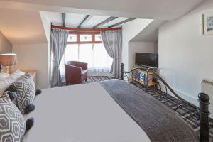 a bedroom with a bed and a tv and a window at Apartment 4, Khyber Lodge Apartment Whitby in Whitby