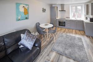 a living room with a couch and a table and a kitchen at Apartment 4, Khyber Lodge Apartment Whitby in Whitby