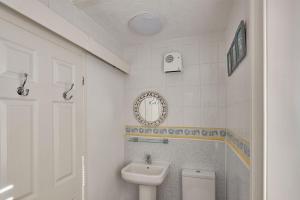 Baño blanco con aseo y lavamanos en Apartment 4, Khyber Lodge Apartment Whitby en Whitby