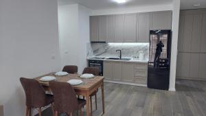 eine Küche mit einem Holztisch und einem Kühlschrank in der Unterkunft Amelja's Apartment in Shkodra