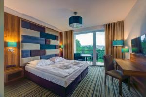 Pokój hotelowy z łóżkiem, biurkiem i biurkiem w obiekcie Solina Resort w Polańczyku