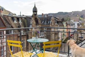 a dog sitting on a balcony with a table and chairs at Ferienwohnung Vino in Cochem