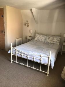 a bedroom with a bed with a white bed frame at The Malt Scoop Inn in Merton