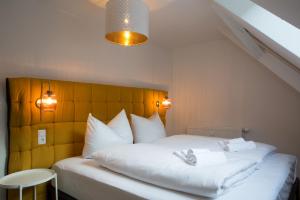 a bedroom with a white bed with a yellow headboard at Ferienwohnung Vino in Cochem