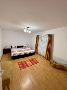 a bedroom with a bed and a wooden floor at Cabana Lirca in Răstoliţa