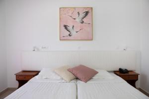 a bedroom with two beds and a picture of birds at Sea Breeze Hotel in Mastichari