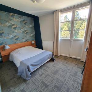 CraonにあるHOTEL RESTAURANT Crêperie du Châteauのベッドルーム1室(ベッド1台付)が備わります。壁には絵画が飾られています。