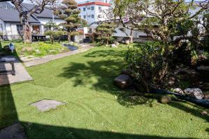 伊豆の宿　静海 في إيتو: ساحة بها عشب أخضر وأشجار ومبنى