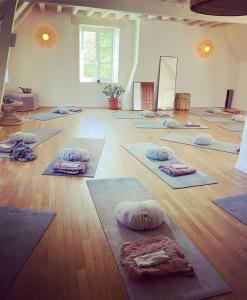 una sala de yoga con muchas esterillas en el suelo en The Holy Farmhouse, en Fontaine-Simon