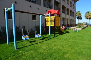 a playground in a yard next to a building at Fame Residence Kemer & Spa in Kemer