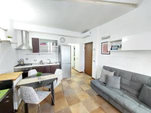 cocina y sala de estar con sofá y mesa en Silvia Apartment, en Florencia