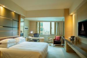Habitación de hotel con cama, escritorio y silla en Hengshan Garden Hotel, en Shanghái