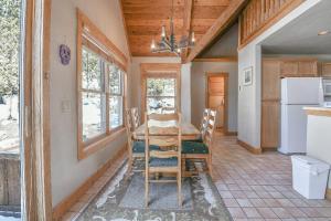 a dining room with a table and chairs and a refrigerator at Cabin In The Pines 11 in Keystone