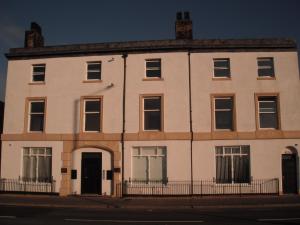 un viejo edificio blanco en la esquina de una calle en Victoria Quays Apartments, Fleetwood, en Fleetwood