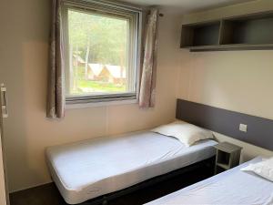 - une petite chambre avec 2 lits et une fenêtre dans l'établissement Camping Olva ***, à Sartène
