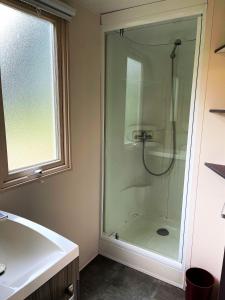 baño con ducha, lavabo y ventana en Camping Olva ***, en Sartène