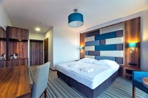pokój hotelowy z łóżkiem i stołem w obiekcie Solina Resort w Polańczyku