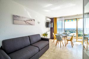 een woonkamer met een bank en een tafel bij Cannes Marina Appart Hotel Mandelieu in Mandelieu-la-Napoule