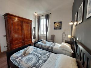 a bedroom with two beds and a wooden cabinet at Savieri Home in Florence in Florence