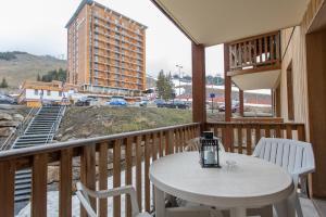 balkon ze stołem i krzesłami oraz budynek w obiekcie L'Etoile d'Orcières Merlette - Au pieds des pistes w mieście Orcières