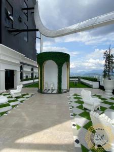 un patio al aire libre con arco y sillas blancas en Arte MontKiara Cozy n Spacious 1BR 100mbps_Jacuzzi, en Kuala Lumpur