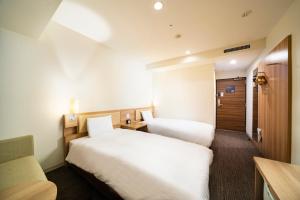Postel nebo postele na pokoji v ubytování KOKO HOTEL Sapporo Ekimae
