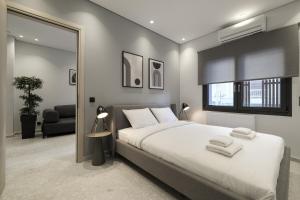 a bedroom with a large white bed and a mirror at Athenian Island Project in Athens
