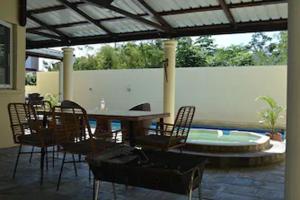 une terrasse avec une table, des chaises et une piscine dans l'établissement Magnifique Villa avec piscine privée à 550 m de la plage, à Trou aux Biches