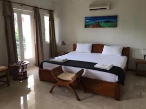 a bedroom with a large bed and a chair at Villa Begonia - Magnifique Villa avec piscine privée à 550 m de la plage in Trou aux Biches +58 photos