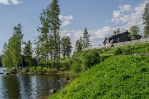 uma casa no topo de uma colina ao lado de um rio em Kloten Nature Resort em Kopparberg