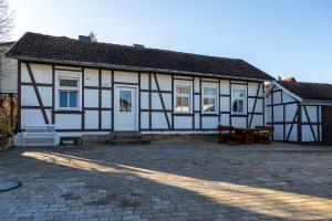 a large white and black building with a patio at Blablu - Ferienhaus Bäckerei Koch in Blankenburg