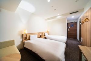 Postel nebo postele na pokoji v ubytování KOKO HOTEL Sapporo Ekimae
