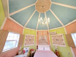 sypialnia z 2 łóżkami i żyrandolem w obiekcie Olive Vanilla Pension w mieście Gyeongju