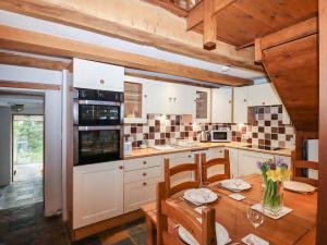 a kitchen with a wooden table and a dining room at Two Shoes Cottage in Okehampton
