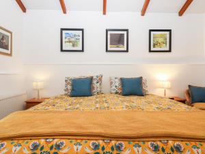sypialnia z dużym łóżkiem z niebieskimi poduszkami w obiekcie Two Shoes Cottage w mieście Okehampton