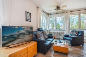 Una sala de estar con dos sillas y un televisor de pantalla plana. en Villa Seepark - 12, en Heringsdorf
