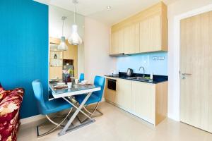a small kitchen with a table and a blue wall at Grande Carribean sea view apartments Jomtien beach in Pattaya South