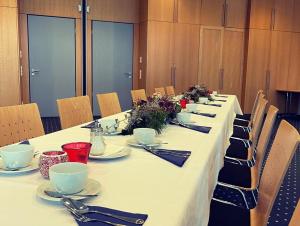 una mesa larga con platos y utensilios. en Nordic Avantage Hotel en Kiel