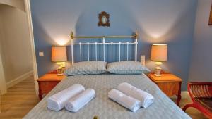 a large bed with white pillows and two lamps at Heron's Path II in Análipsis