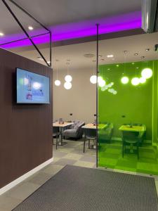 a room with a tv on a wall with green walls at Hotel Miramonti in Turin