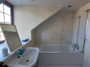 a bathroom with a bath tub and a sink at The Manor House, Curry Mallet in Taunton