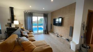 a living room with a couch and a flat screen tv at Casa Xisca in Cala Pi