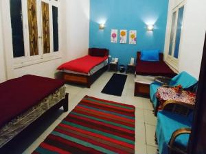 un soggiorno con 3 letti e un tappeto di اللوكاندة الجديدة New Hotel ad Alessandria d'Egitto
