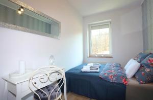 Un dormitorio con una cama, una silla y un espejo. en Apartament Winston, en Szczawno-Zdrój