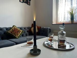 a table with two glasses and a candle on it at Apartament Winston in Szczawno-Zdrój